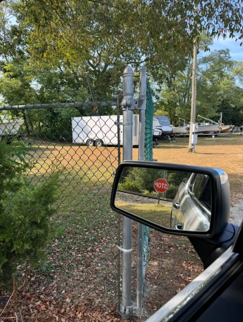 showing the fenced in yard with a trailer, camper and boat inside